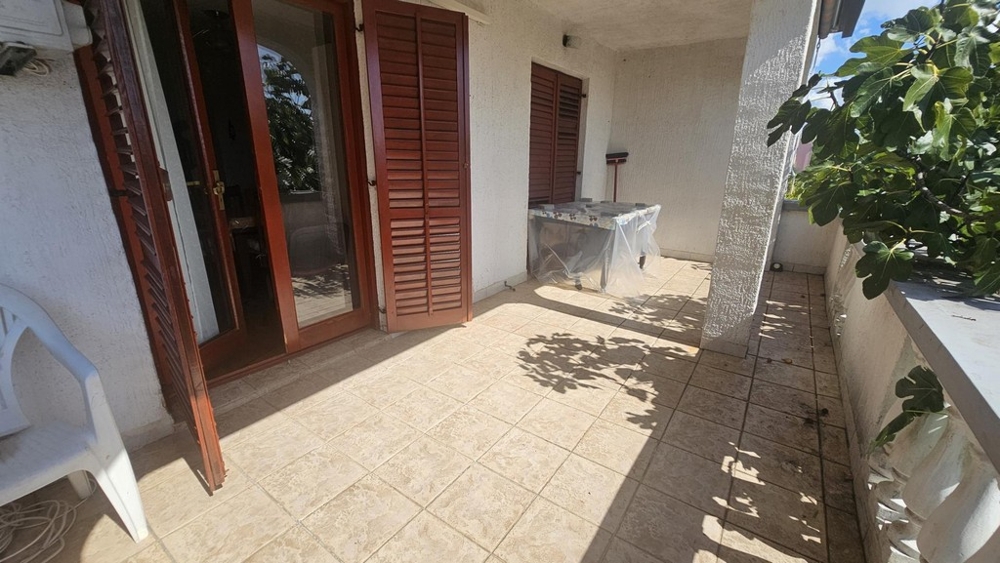 Krytá terasa s dlažbou a drevenými okenicami