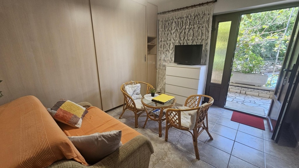 Obývacia izba na prízemí s pohovkou a ratanovým nábytkom