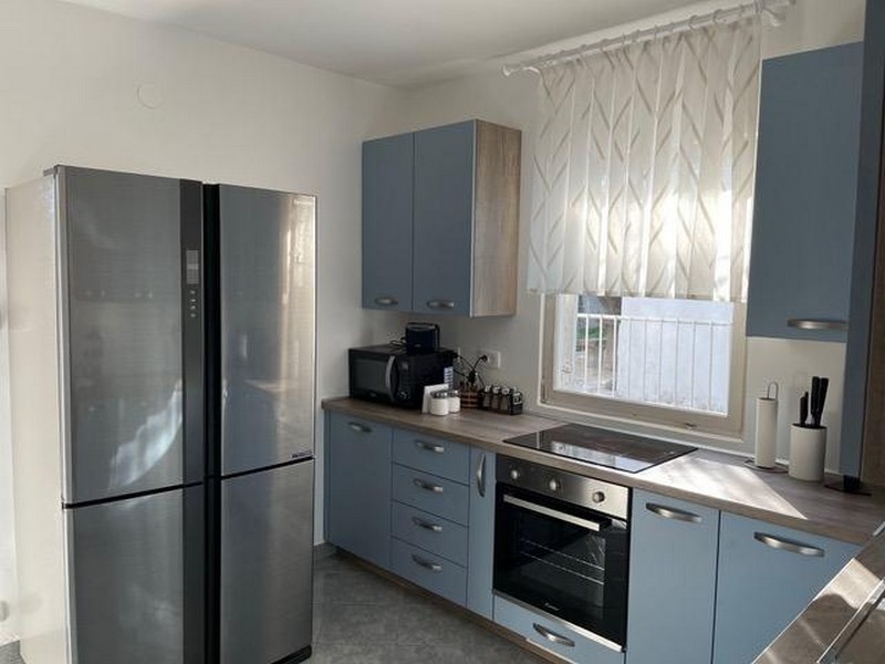 Moderná kuchynská linka so vstavanými spotrebičmi a oknom