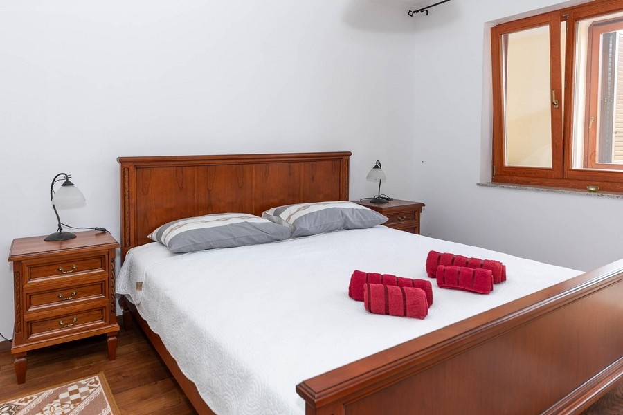 Spálňa s manželskou posteľou a drevenými nočnými stolíkmi