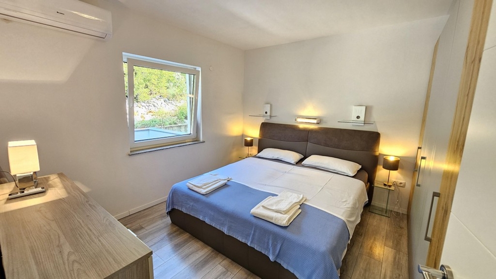 Spálňa s manželskou posteľou a nočnými stolíkmi