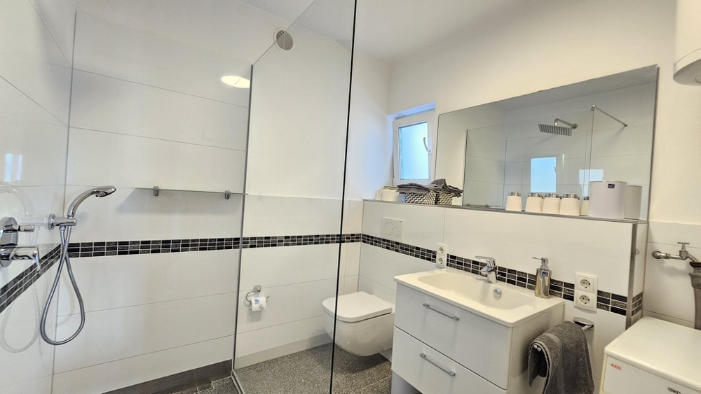 Moderná kúpeľňa so sprchovacím kútom a umývadlom