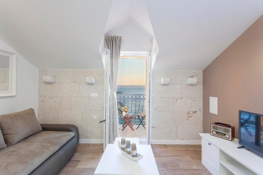 Obývacia izba s prístupom na balkón a výhľadom na more