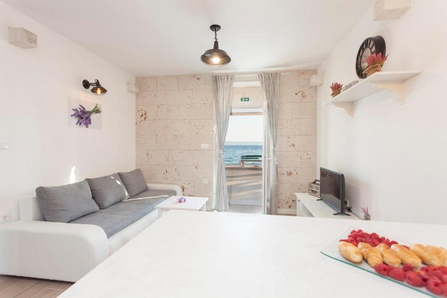 Svetlá obývacia izba s pohovkou a výhľadom na more
