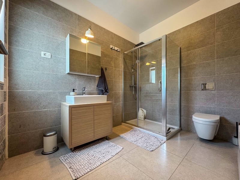 Moderná kúpeľňa so sprchovacím kútom a umývadlom