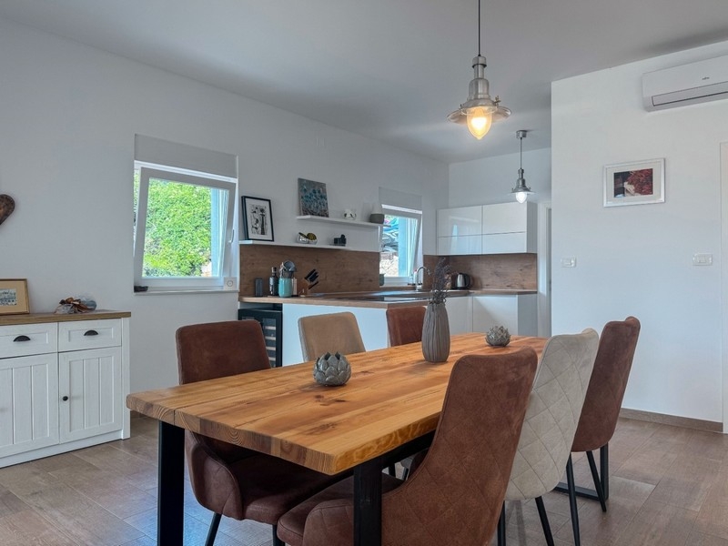 Jedálenský kút s dreveným stolom a modernou kuchyňou