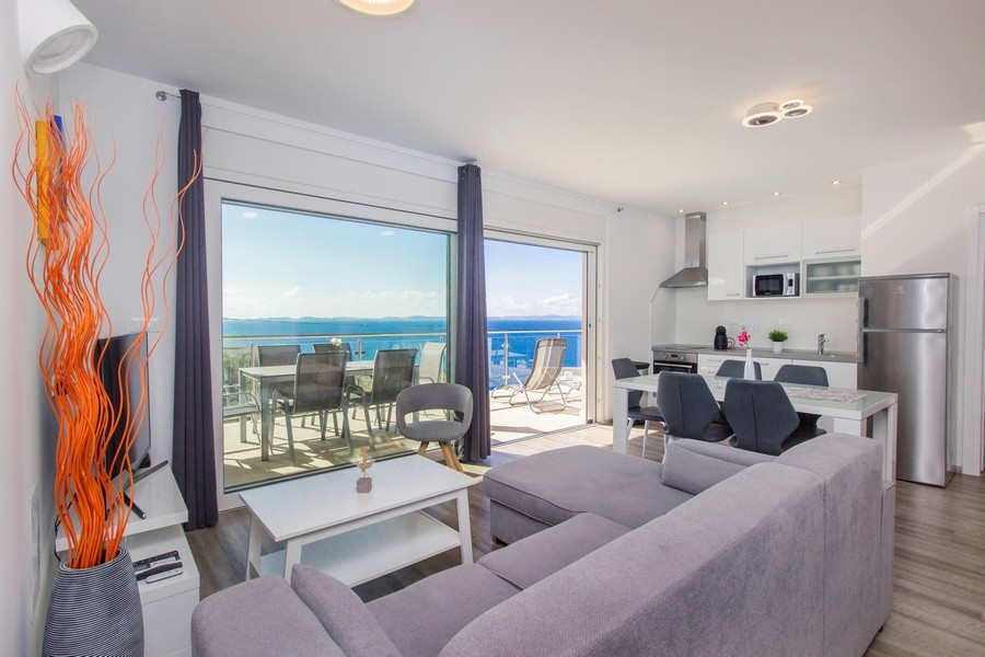 Obývacia izba s kuchyňou a vstupom na terasu s výhľadom na more
