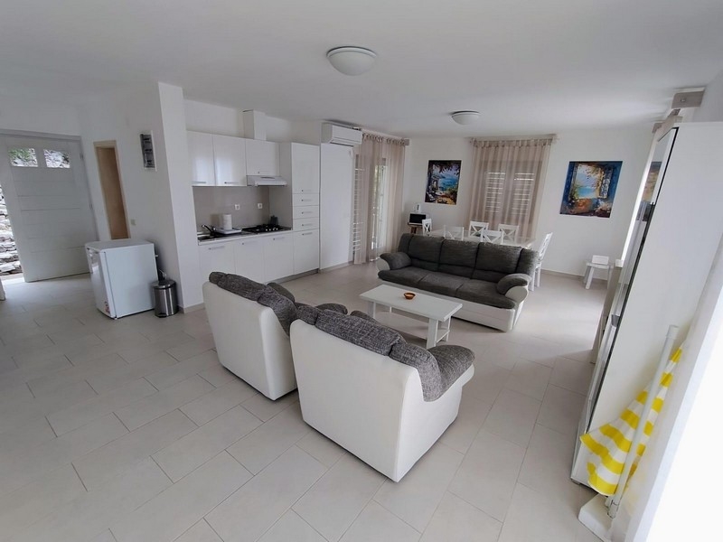 Svetlá obývacia izba s otvorenou kuchyňou a pohovkami