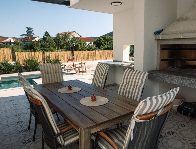 Gril a výhľad na bazén z jedálne.