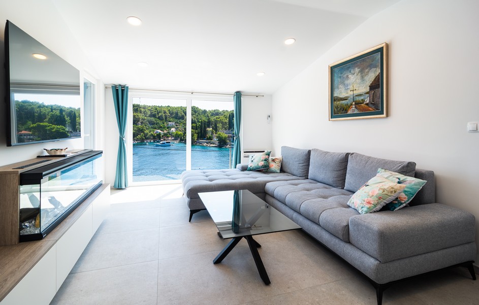 Moderná obývacia izba s výhľadom na more a veľkým preskleným priečelím