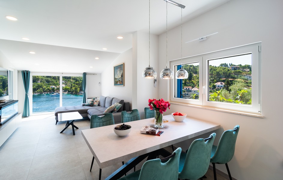 Svetlá obývacia izba s jedálenským stolom a výhľadom na záliv