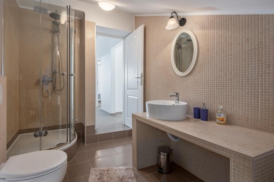 Kúpeľňa s okrúhlym sprchovacím kútom a umývadlom