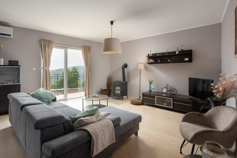 Moderná obývacia izba so vstupom na balkón a výhľadom na more