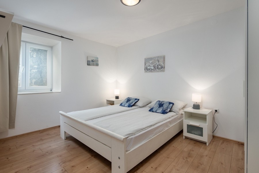 Svetlá spálňa s manželskou posteľou a drevenou podlahou