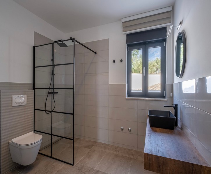 Moderná kúpeľňa s veľkým sprchovacím kútom a dreveným umývadlom