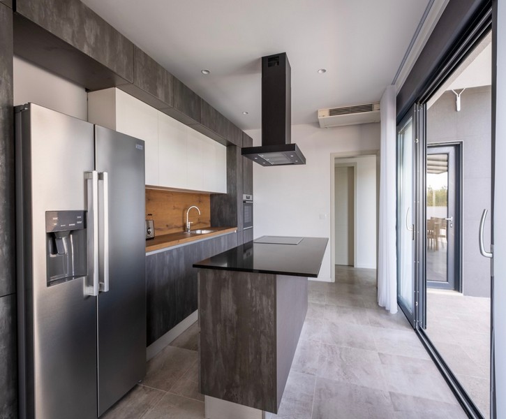 Moderná kuchyňa s ostrovčekom na varenie a vstupom na terasu