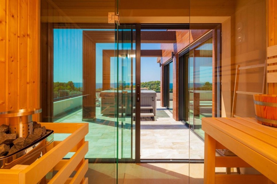 Sauna s preskleným priečelím a vstupom na terasu s výhľadom na more