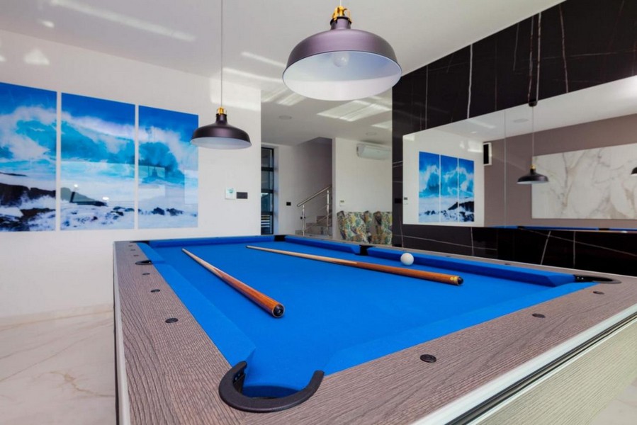 Obývacia časť s moderným biliardovým stolom a štýlovým osvetlením