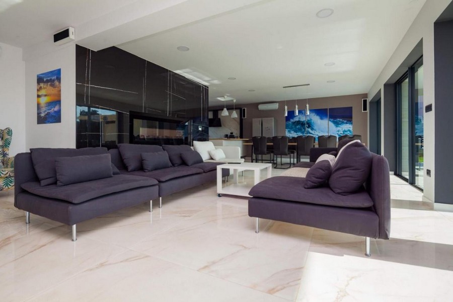 Priestranná obývacia izba s oknami od podlahy až po strop a moderným nábytkom