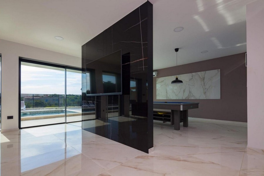 Otvorený obývací priestor s modernými prvkami a výhľadom na bazén