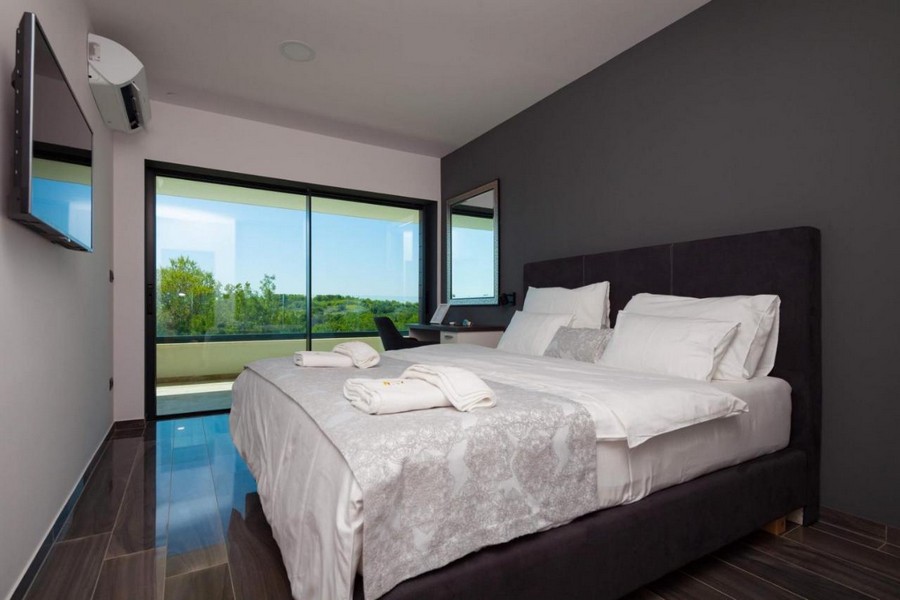 Elegantná spálňa s manželskou posteľou a výhľadom na krajinu