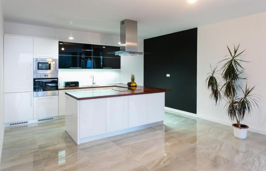 Moderne vybavená kuchyňa s ostrovčekom na varenie a výhľadom do záhrady