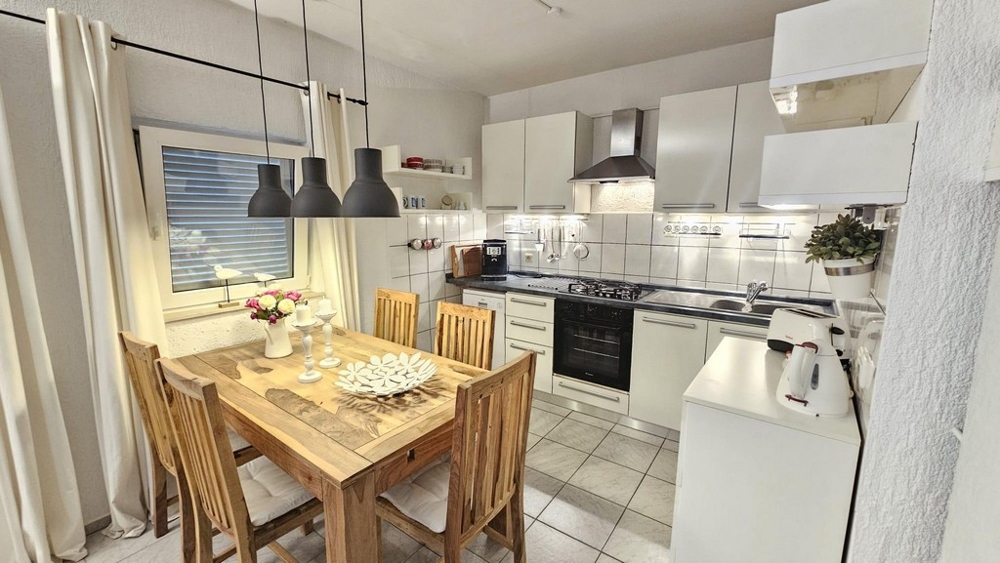 Jedálenský kút a kuchyňa s dreveným stolom a modernými lampami