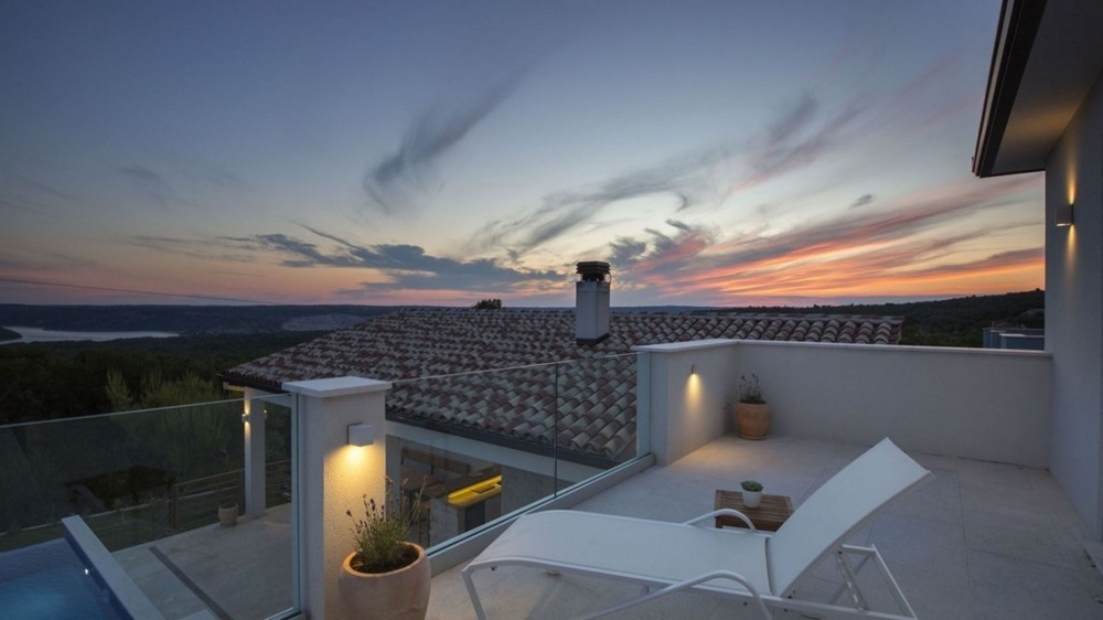 Terasa vily s ležadlami a panoramatickým výhľadom pri západe slnka