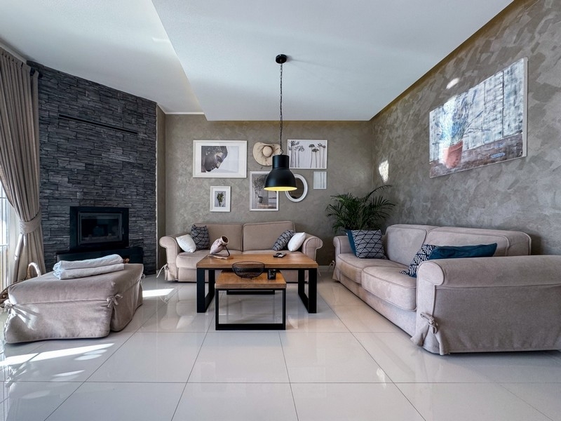 Obývacia izba s krbom, pohovkami a štýlovým dizajnom