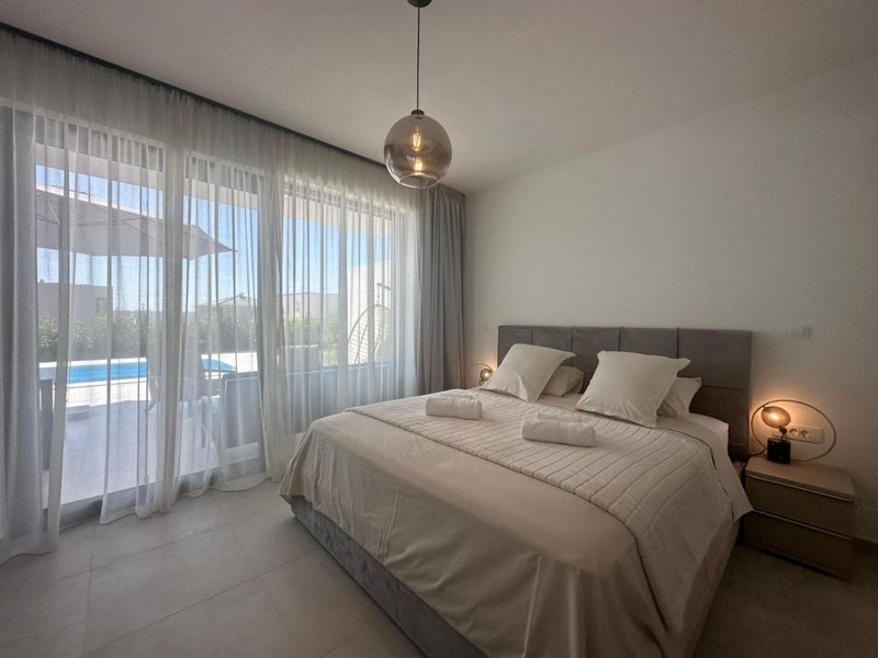 Spálňa s moderným dizajnom a výhľadom na bazén