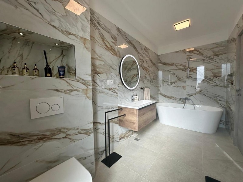 Kúpeľňa s voľne stojacou vaňou a mramorovým dizajnom