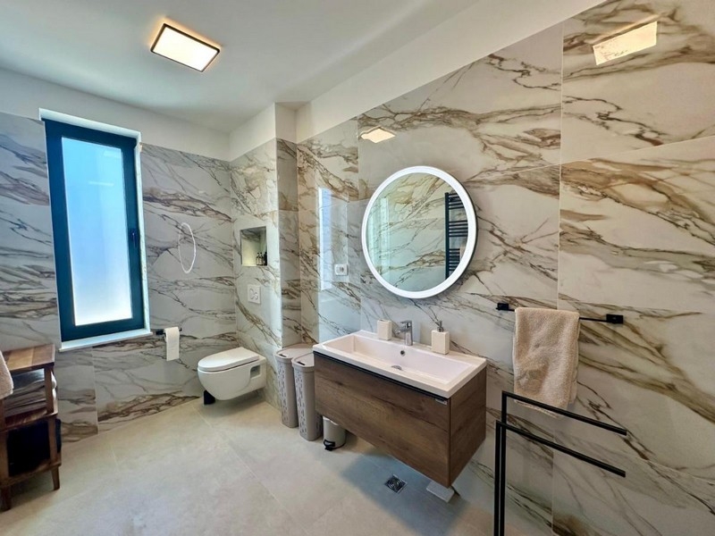 Moderná kúpeľňa s dvojitým umývadlom a mramorovými stenami