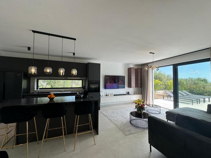 Moderná kuchyňa s jedálenským kútom a výhľadom na terasu.