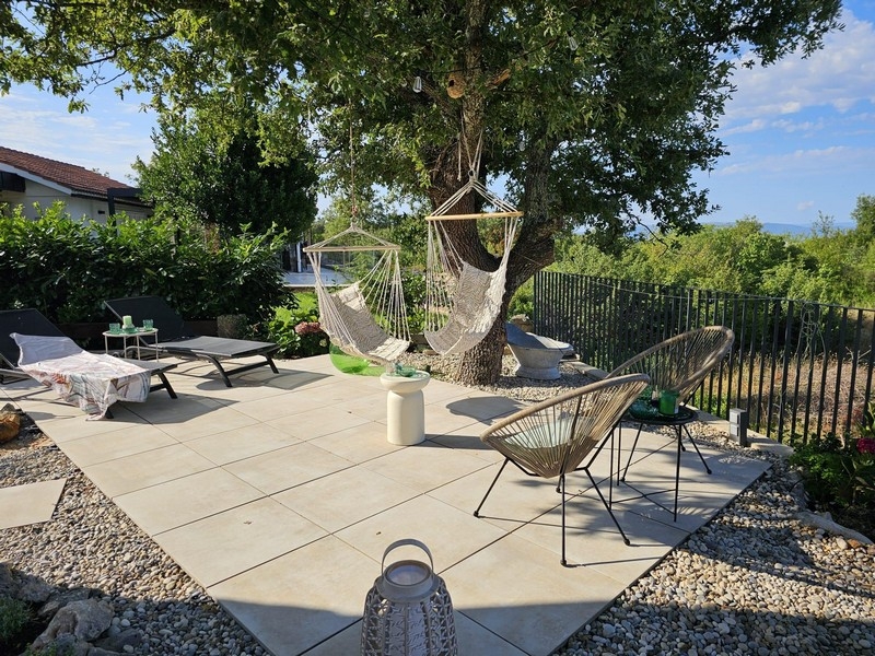 Slnečná terasa so závesnými stoličkami a výhľadom do záhrady