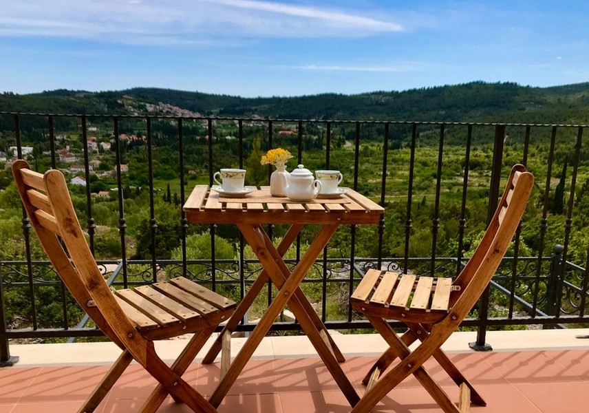 Balkón so stolom a stoličkami, výhľad na kopce