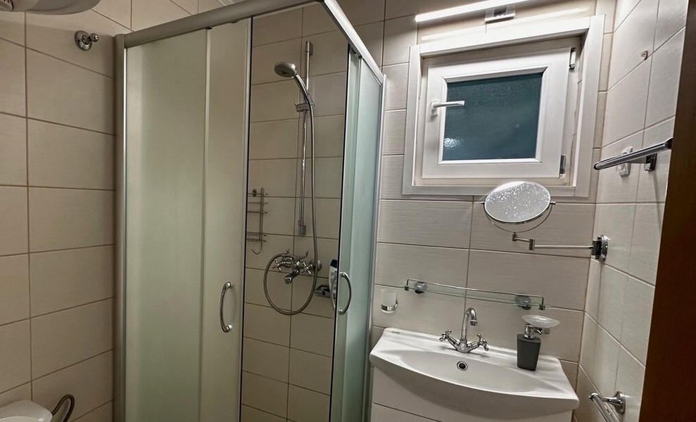 Kúpeľňa so sprchovacím kútom a umývadlom