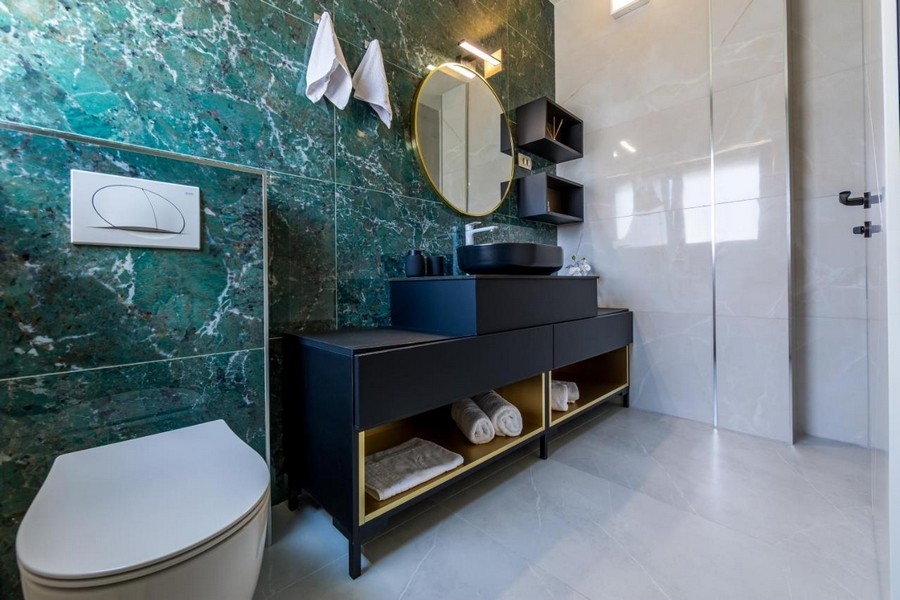 Kúpeľňa so zelenou mramorovou stenou a moderným umývadlom