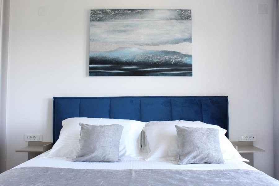 Manželská posteľ v modernej spálni s dekoratívnou nástennou maľbou