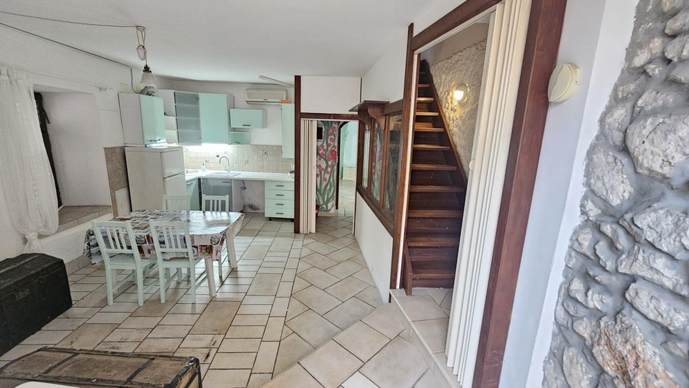 Obývacia časť s kuchyňou a drevenými schodmi