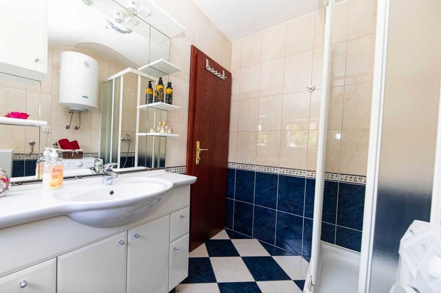 Kúpeľňa so sprchovacím kútom a modro-bielou dlažbou