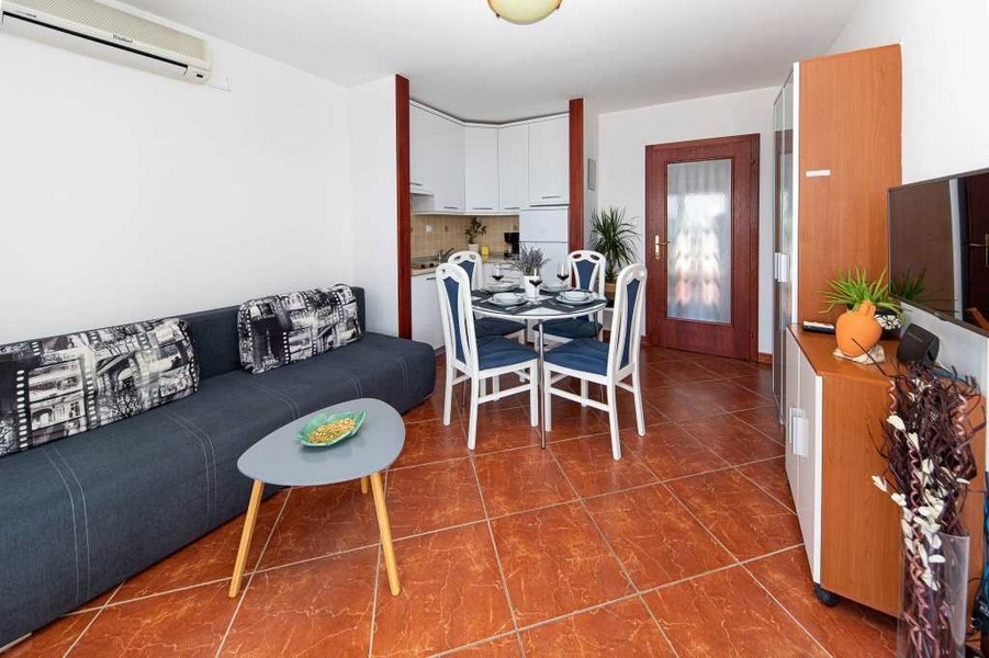 Obývacia izba s bielou kuchyňou a jedálenským kútom