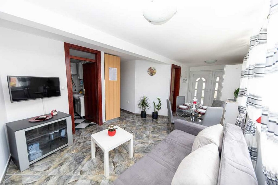 Svetlá obývacia izba s posedením a vstupom do kúpeľne