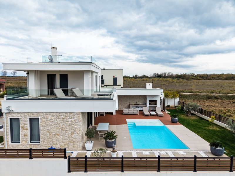 Bočný výhľad na vilu s veľkou terasou a bazénom