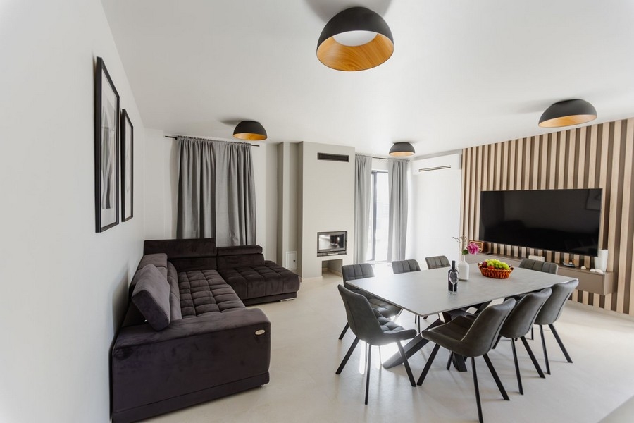 Obývacia izba s veľkým jedálenským stolom a krbom