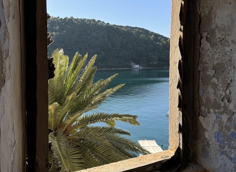 Výhľad na more cez otvorené okno starého majetku