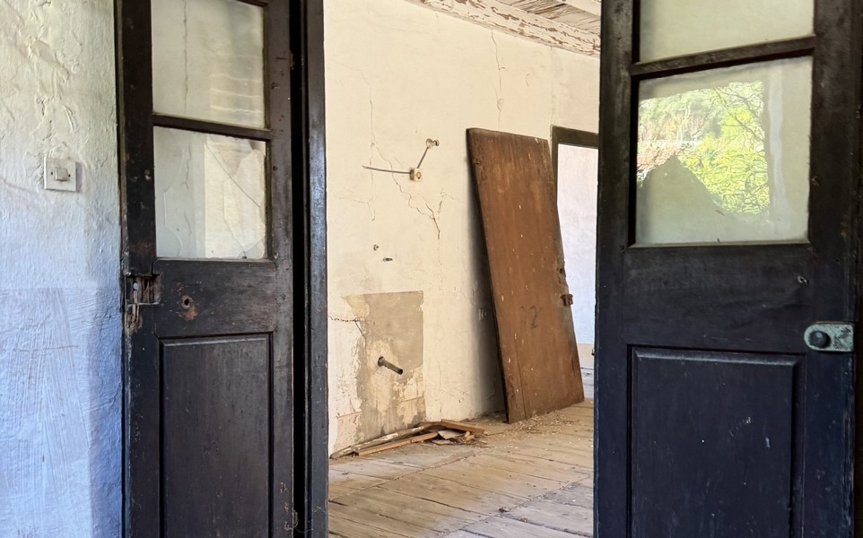 Interiér s otvorenými dverami a viditeľnou potrebou renovácie