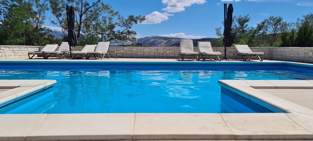 Bazén s ležadlami a slnečníkmi vo vile H3768 na Rabe