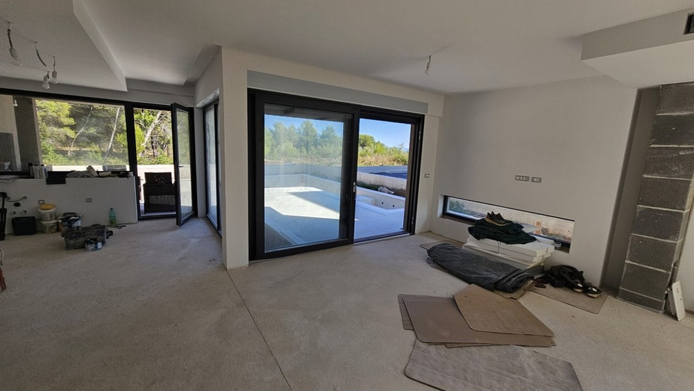 Obytný priestor v hrubej stavbe s presklenou stenou k bazénu - vila H3778 v Privlake.