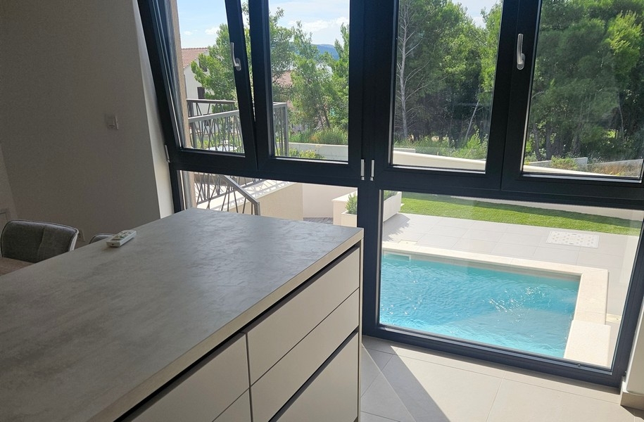 Kuchynský kút s výhľadom na bazén a záhradu