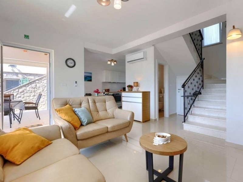 Obývacia časť s pohovkou, schodiskom a výstupom na terasu